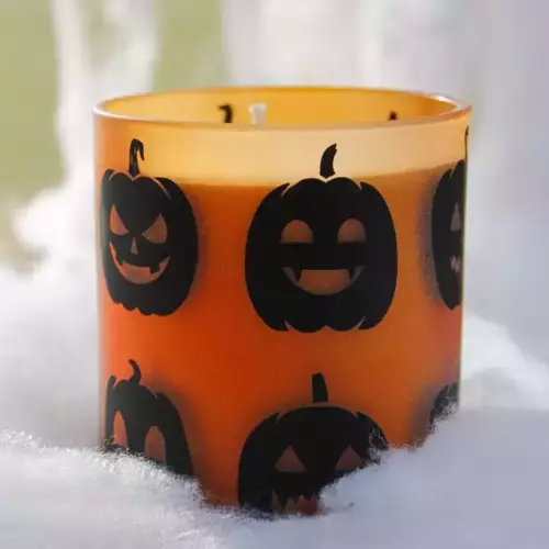 Bougie pot en verre avec citrouilles fond orange