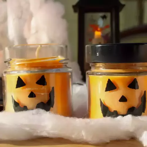 Bougie citrouilles dans un pot en verre transparent avec couvercle noir