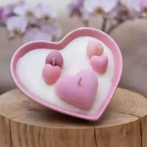 Bougie dans un contenant en porcelaine rose en forme de cœur