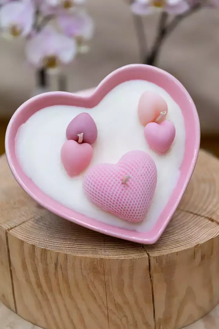 Bougie dans un contenant en porcelaine rose en forme de cœur