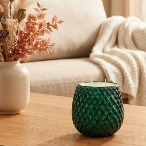 Bougie de couleur vert bronze, de forme allongée, dans un contenant de chez Loberon.